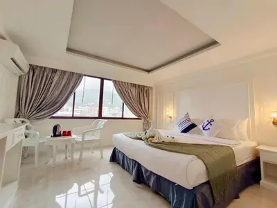 a hotel room with a large bed and a desk at Chilli House Residence in Patong Beach