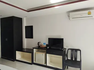 a living room with a tv and a black desk at Chilli House Residence in Patong Beach