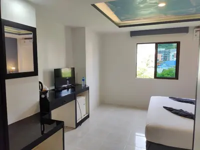 a hotel room with a bed and a mirror at Chilli House Residence in Patong Beach