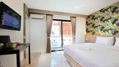 a hotel room with a bed and a tv at Chilli House Residence in Patong Beach