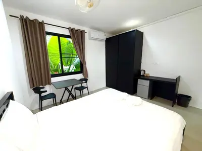a bedroom with a bed and a desk and a window at Patong Easy Life 1 in Patong Beach
