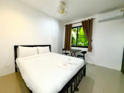 a bedroom with a large white bed and a window at Patong Easy Life 1 in Patong Beach
