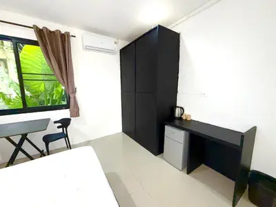 a room with a desk and a table and a window at Patong Easy Life 1 in Patong Beach