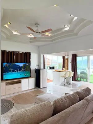 a living room with a couch and a flat screen tv at Villa Seaview Patong in Patong Beach