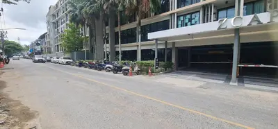 a building with cars parked on the side of a street at Modern studio in Boat Avenue close to the beach in Bang Tao Beach