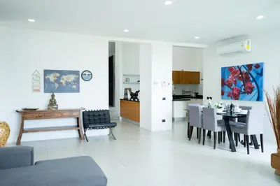 a living room and kitchen with a table and chairs at Sirirat Sea-view Villa in Patong Beach