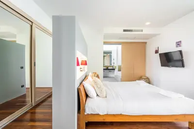 a bedroom with a bed and a tv on a wall at Sirirat Sea-view Villa in Patong Beach