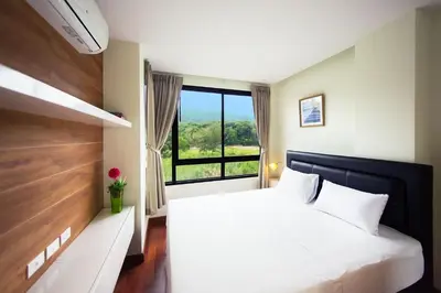 a bedroom with a large white bed with a large window at LAGO APARTMENTS BY TROPICLOOK in Nai Harn Beach