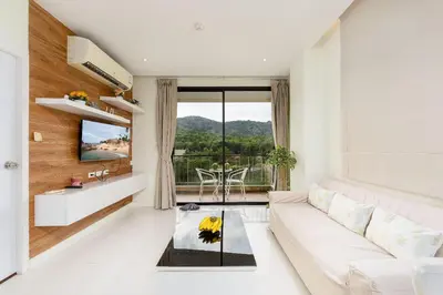 a living room with a white couch and a table at LAGO APARTMENTS BY TROPICLOOK in Nai Harn Beach