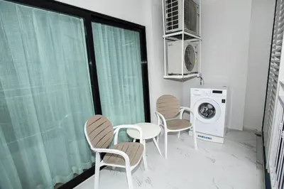 a laundry room with chairs and a washing machine at ME5 Halo 2-bedroom ВатСaп66935B2I976 вид на бассейн in Nai Yang Beach