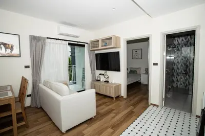 a living room with a white couch and a television at ME5 Halo 2-bedroom ВатСaп66935B2I976 вид на бассейн in Nai Yang Beach