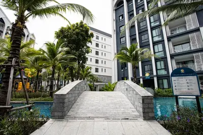 a walkway in a city with palm trees and buildings at ME5 Halo 2-bedroom ВатСaп66935B2I976 вид на бассейн in Nai Yang Beach