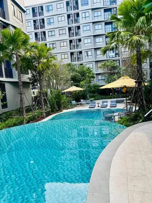 a large swimming pool in front of a tall building at Poolside Paradise, Nice pool view in Kathu