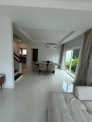 a white living room with a table and a couch at Supalai Rent BANG TAO PHUKET in Phuket