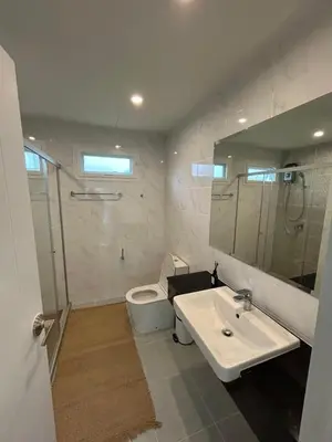 a bathroom with a sink and a toilet and a mirror at Supalai Rent BANG TAO PHUKET in Phuket