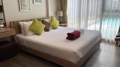 a bedroom with a large bed with pillows and a window at The deck patong 2bedroom in Patong Beach