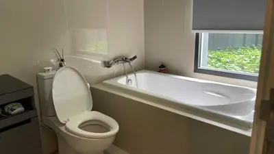 a bathroom with a toilet and a tub and a sink at The deck patong 2bedroom in Patong Beach