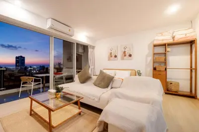 a living room with a white couch and a large window at Seaview Residence Karon beach in Karon Beach