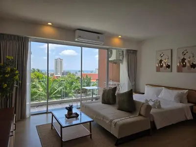 a bedroom with a bed and a couch and a large window at Seaview Residence Karon beach in Karon Beach