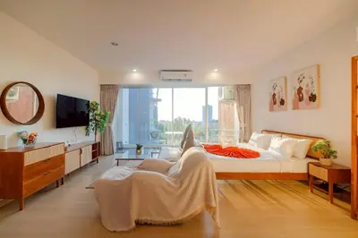 a bedroom with a bed and a chair and a tv at Seaview Residence Karon beach in Karon Beach