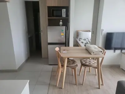 a kitchen with a table and two chairs and a refrigerator at Sky Park Laguna Residences F5 in Laguna Phuket