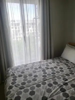 a bed in a room with a large window at Sky Park Laguna Residences F5 in Laguna Phuket