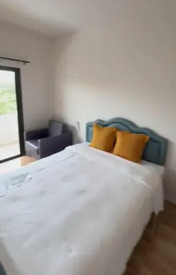 a bedroom with a large white bed with two yellow pillows at KK Apartment BangJo, Phuket in Koh Lone