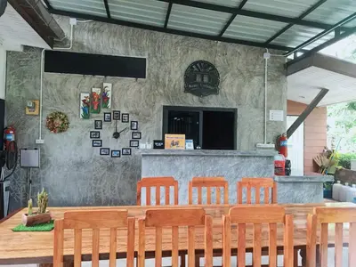 a restaurant with a table with chairs and a counter at Finlay Cottage Aonang in Ban Khlong Haeng