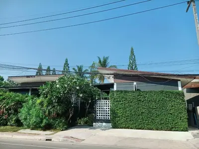 a house with a hedge in front of a street at Finlay Cottage Aonang in Ban Khlong Haeng