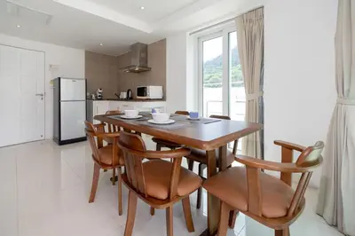 a kitchen and dining room with a wooden table and chairs at Kata Ocean View I05 in Karon Beach