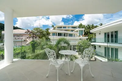 a balcony with a table and chairs and a building at Kata Ocean View I05 in Karon Beach