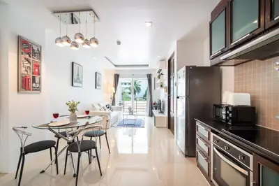 a kitchen with a table and chairs and a living room at \u82ad\u4e1cHavenLagoon612\u7cbe\u88c5\u4e00\u5367\u5ba4\u516c\u5bd3 \u8fd1\u82ad\u4e1c\u6d77\u6ee9\u751f\u6d3b\u4fbf\u5229 in Patong Beach