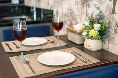 a table with two glasses of wine and plates on it at \u65b0\u623f\u7279\u60e0 \u82ad\u4e1cTheDeck10\u7cbe\u88c5\u4e00\u5367\u5ba4\u516c\u5bd3 \u8fd1\u82ad\u4e1c\u6d77\u6ee9Bangla\u6c5f\u897f\u51b7 in Patong Beach