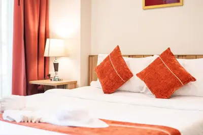 a hotel room with two beds with orange and white pillows at \u65b0\u623f\u7279\u60e0 \u82ad\u4e1cTheDeck10\u7cbe\u88c5\u4e00\u5367\u5ba4\u516c\u5bd3 \u8fd1\u82ad\u4e1c\u6d77\u6ee9Bangla\u6c5f\u897f\u51b7 in Patong Beach