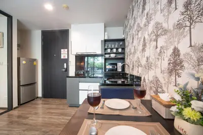 a kitchen with a table with a glass of wine at \u65b0\u623f\u7279\u60e0 \u82ad\u4e1cTheDeck10\u7cbe\u88c5\u4e00\u5367\u5ba4\u516c\u5bd3 \u8fd1\u82ad\u4e1c\u6d77\u6ee9Bangla\u6c5f\u897f\u51b7 in Patong Beach