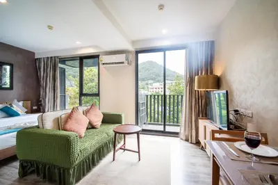 a hotel room with a green couch and a bed at \u82ad\u4e1cTheDeck220\u7cbe\u88c5\u4e00\u5367\u5ba4\u516c\u5bd3 \u8fd1\u82ad\u4e1c\u6d77\u6ee9Bangla\u6c5f\u897f\u51b7 in Patong Beach