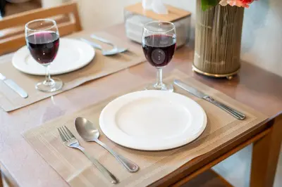a table with two glasses of red wine and silverware at \u82ad\u4e1cTheDeck220\u7cbe\u88c5\u4e00\u5367\u5ba4\u516c\u5bd3 \u8fd1\u82ad\u4e1c\u6d77\u6ee9Bangla\u6c5f\u897f\u51b7 in Patong Beach