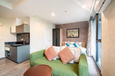 a living room with a couch and a kitchen at \u82ad\u4e1cTheDeck220\u7cbe\u88c5\u4e00\u5367\u5ba4\u516c\u5bd3 \u8fd1\u82ad\u4e1c\u6d77\u6ee9Bangla\u6c5f\u897f\u51b7 in Patong Beach