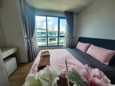 a bedroom with a bed with a window and flowers at cen 1 bed room859 in Ban Rangeng