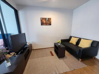 a living room with a black couch and a television at cen 1 bed room859 in Ban Rangeng