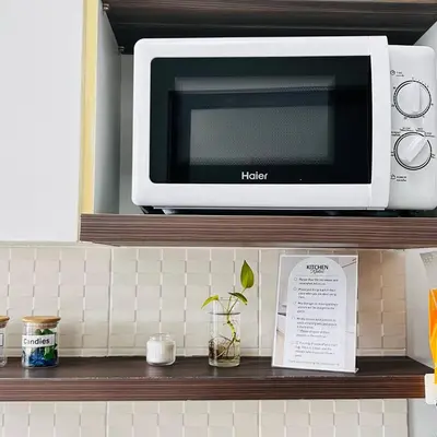 a microwave sitting on a shelf in a kitchen at Vista Phuket Old Town Gym Pool Wifi Netflix Walk to All in Phuket Town