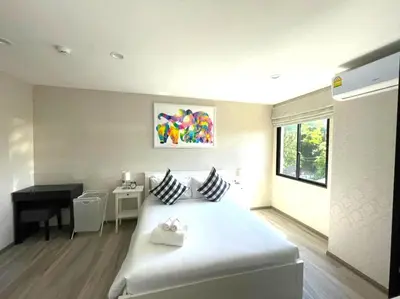 a bedroom with a white bed and a desk in it at С12 Title Naiyang Ватсап669З5В2I976 in Nai Yang Beach
