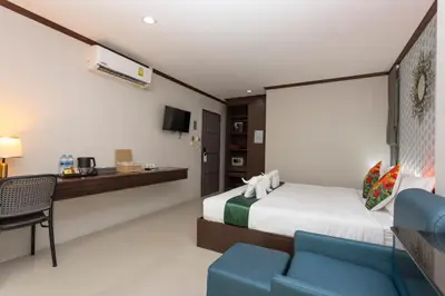 a bedroom with a bed and a desk and a chair at The Chic Patong Hotel in Patong Beach