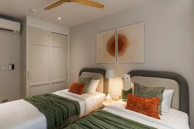 two beds sitting next to each other in a bedroom at NEW! Laguna Beachside Apt 100 m2 in Ban Thalat Choeng Thale