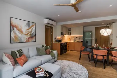 a living room with a couch and a kitchen at NEW! Laguna Beachside Apt 100 m2 in Ban Thalat Choeng Thale