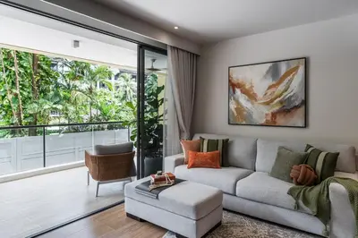 a living room with a couch and a large window at NEW! Laguna Beachside Apt 100 m2 in Ban Thalat Choeng Thale