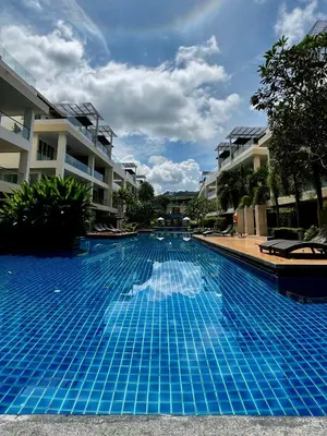 a blue swimming pool in front of some apartment buildings at The Pelican Suite Residence Condo Klong Muang, Krabi in Klong Muang Beach
