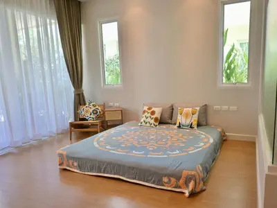 a bedroom with a bed in a room with windows at The Pelican Suite Residence Condo Klong Muang, Krabi in Klong Muang Beach