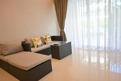 a living room with a couch and a window at The Pelican Suite Residence Condo Klong Muang, Krabi in Klong Muang Beach