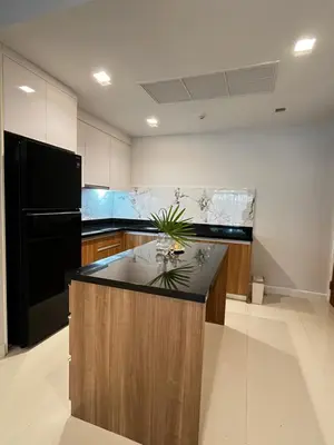 a large kitchen with a black refrigerator and a island at The Pelican Suite Residence Condo Klong Muang, Krabi in Klong Muang Beach